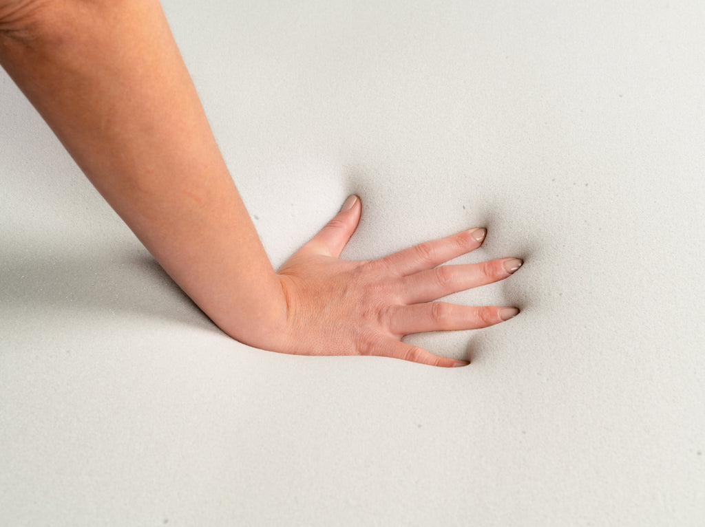 Hand pressing deeply into the 4 lb Memory Foam Mattress Topper to demonstrate contouring support.