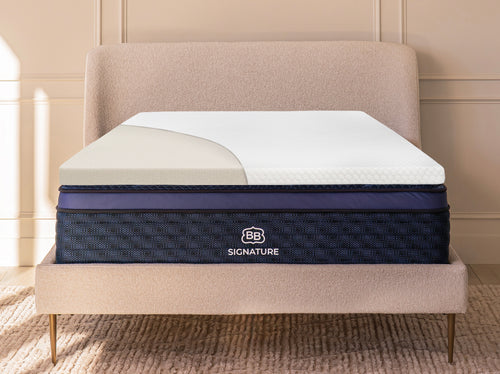 Memory foam mattress topper displayed on a bed with partial cutaway showing internal foam layer.