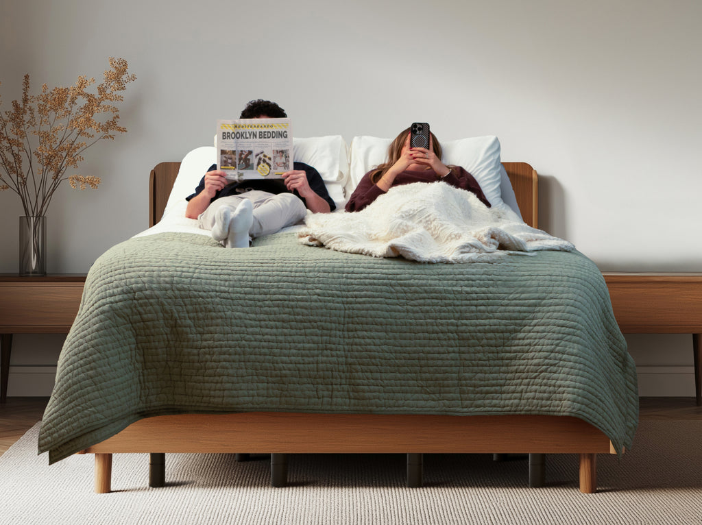 Two people relaxing on Aurora Luxe Cooling mattresses on the Ascension® Ultra Adjustable Power Base, with one person reading and the other using a phone.