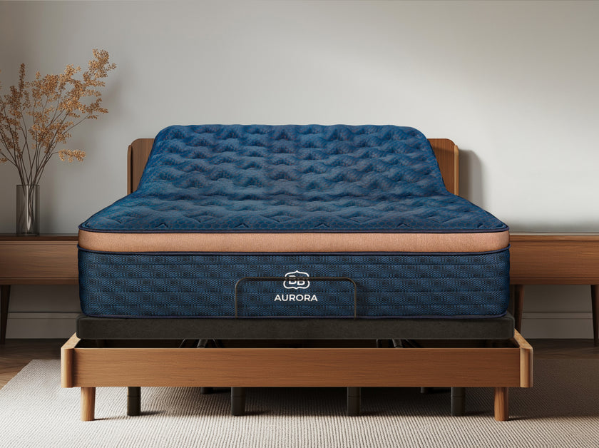 Aurora Luxe Cooling mattress on the Ascension® Ultra Adjustable Power Base with the head section raised inside a wood bed frame.