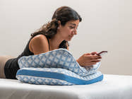 Brooklyn Bedding Luxury Cooling Gel Memory Foam Pillows used in lifestyle with woman leaning on them with her phone. 
