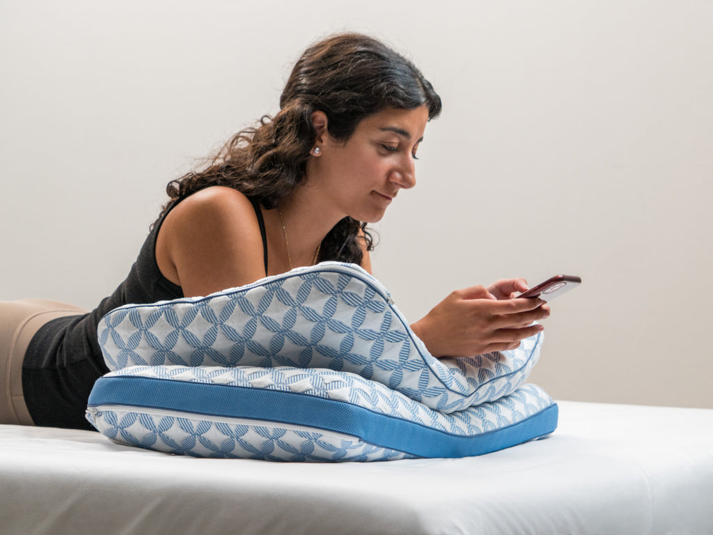Brooklyn Bedding Luxury Cooling Gel Memory Foam Pillows used in lifestyle with woman leaning on them with her phone. 