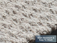 Close-up of the gray plush pet bed surface showing soft textured fabric. Text reads “Stain Resistant.”