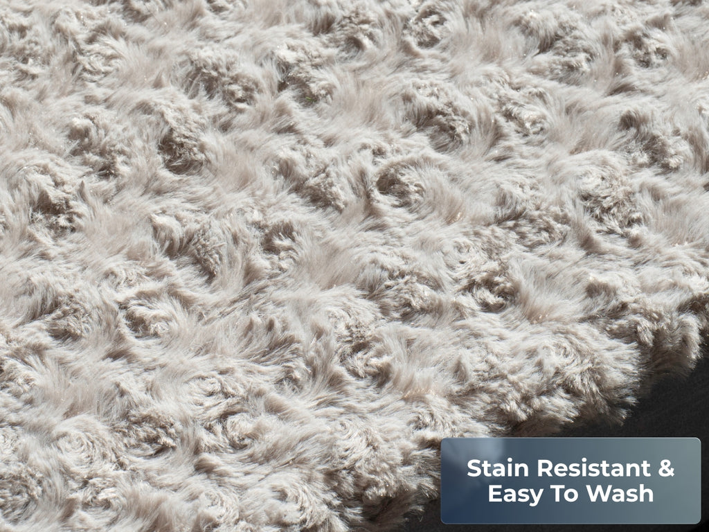 Close-up of the gray plush pet bed surface showing soft textured fabric. Text reads “Stain Resistant.”
