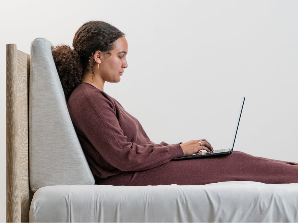 Woman in bed using Brooklyn Bedding Wedge Pillow
