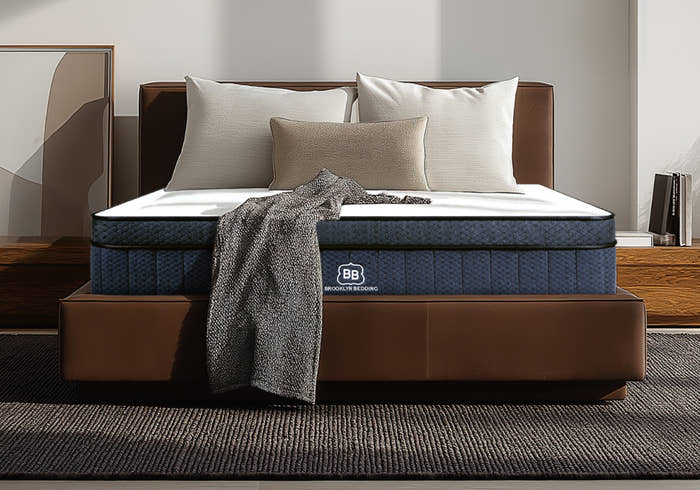 Mattress on a bed with pillows and a blanket in a bedroom setting. Wholesale Brooklyn Bedding collection