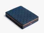Angled studio view of the Brooklyn Bedding Aurora Luxe Cooling mattress in deep blue with copper side panel detailing, shown on a light gray background.