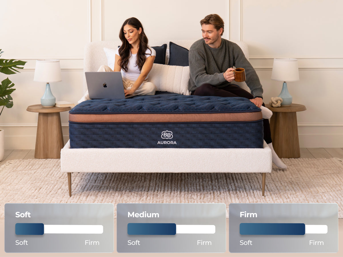 Brooklyn Bedding Aurora Luxe Cooling mattress with two people sitting on the bed and firmness badges labeled “Soft,” “Medium,” and “Firm.”