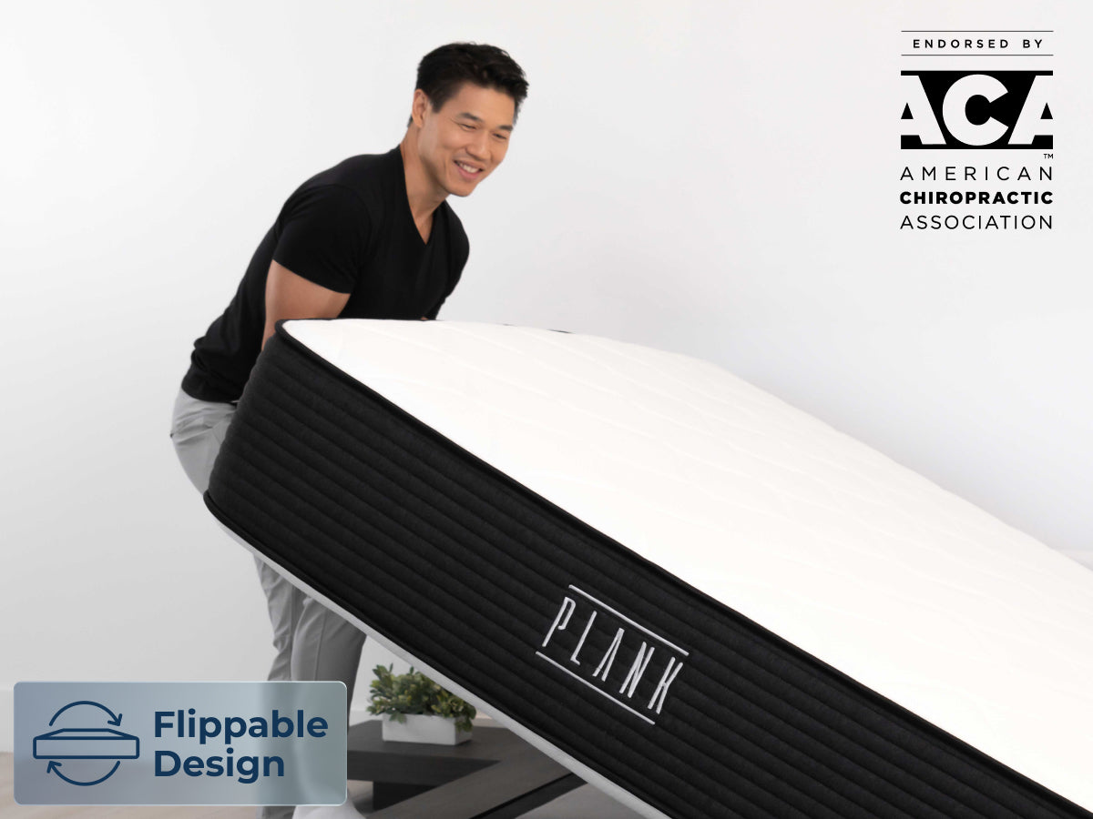 Brooklyn Bedding Plank Firm Mattress being lifted by one person, with a badge reading “Flippable Design,” and an ACA endorsement logo.
