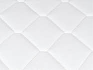 Close-up of the Brooklyn Bedding Plank Firm Mattress white quilted surface with large hexagon stitching.