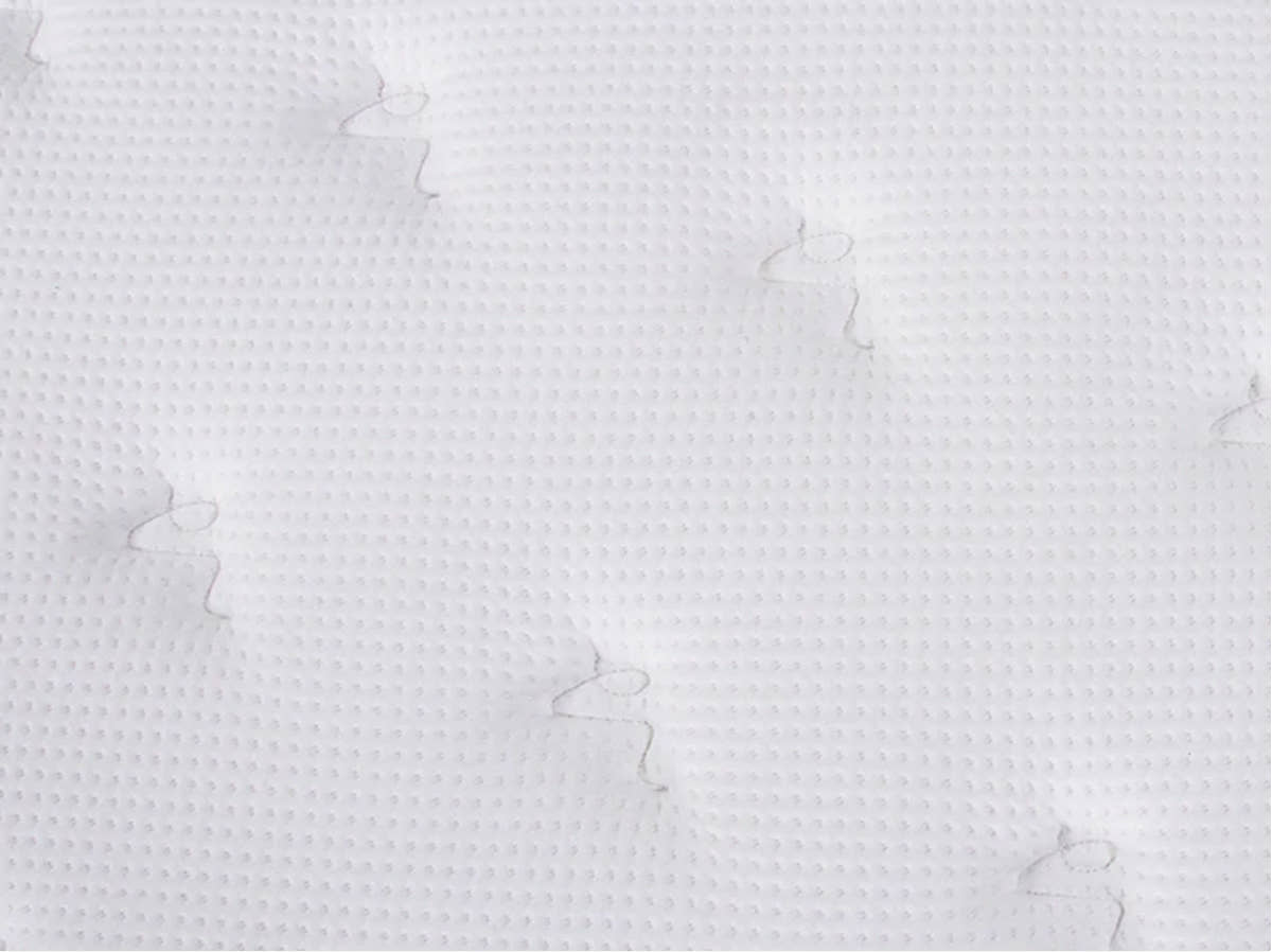 Close-up of the Brooklyn Bedding Plank Firm Mattress white quilted surface with a small textured pattern and tufted stitching.