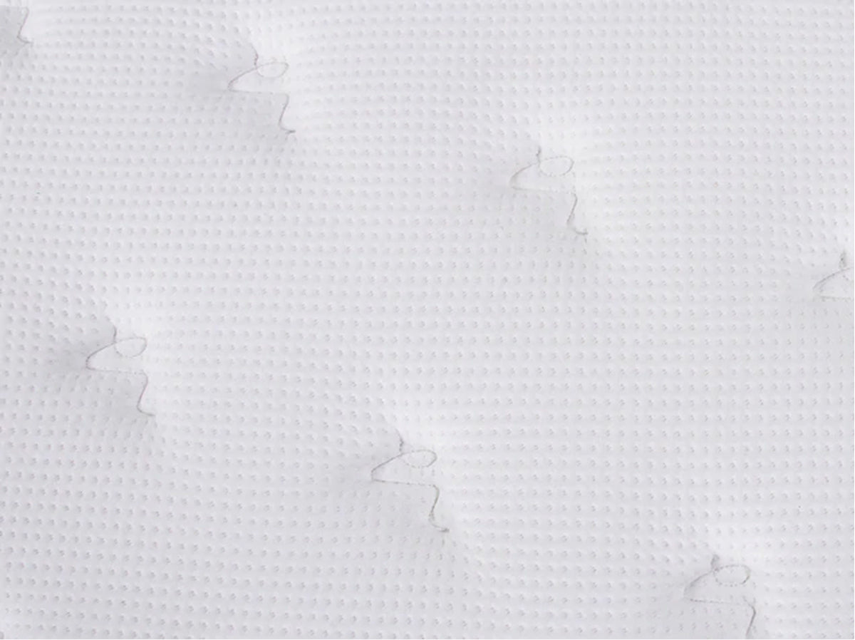 Close-up of the Brooklyn Bedding Plank Firm Mattress white quilted surface with a small textured pattern and tufted stitching.