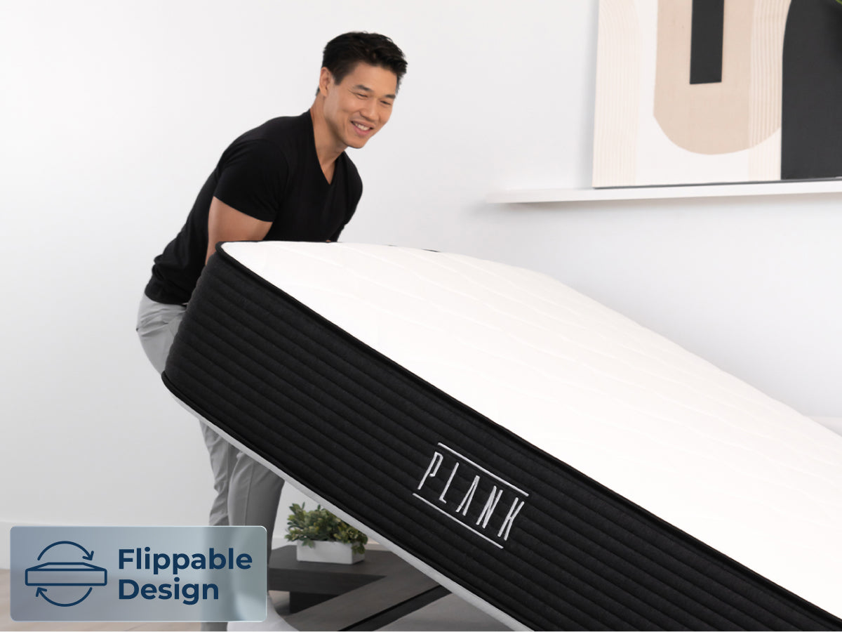 Brooklyn Bedding Plank Firm Luxe mattress being lifted by one person, with a badge reading “Flippable Design.”
