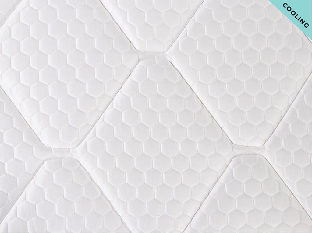 Close-up of the Brooklyn Bedding Plank Firm Luxe cooling surface with white hexagon pattern and tufted stitching, with a “Cooling” corner tag.
