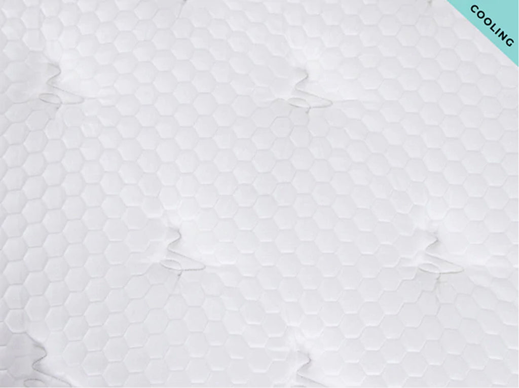 Close-up of the Brooklyn Bedding Plank Firm Luxe cooling surface with white hexagon quilting and a “Cooling” corner tag.
