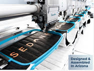 Close-up of Sedona Elite mattress panels being embroidered on a factory machine, with a badge reading “Designed & Assembled In Arizona.”