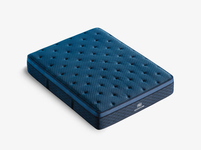 Brooklyn Bedding Signature Hybrid mattress angled on a light gray background with a deep blue quilted top.