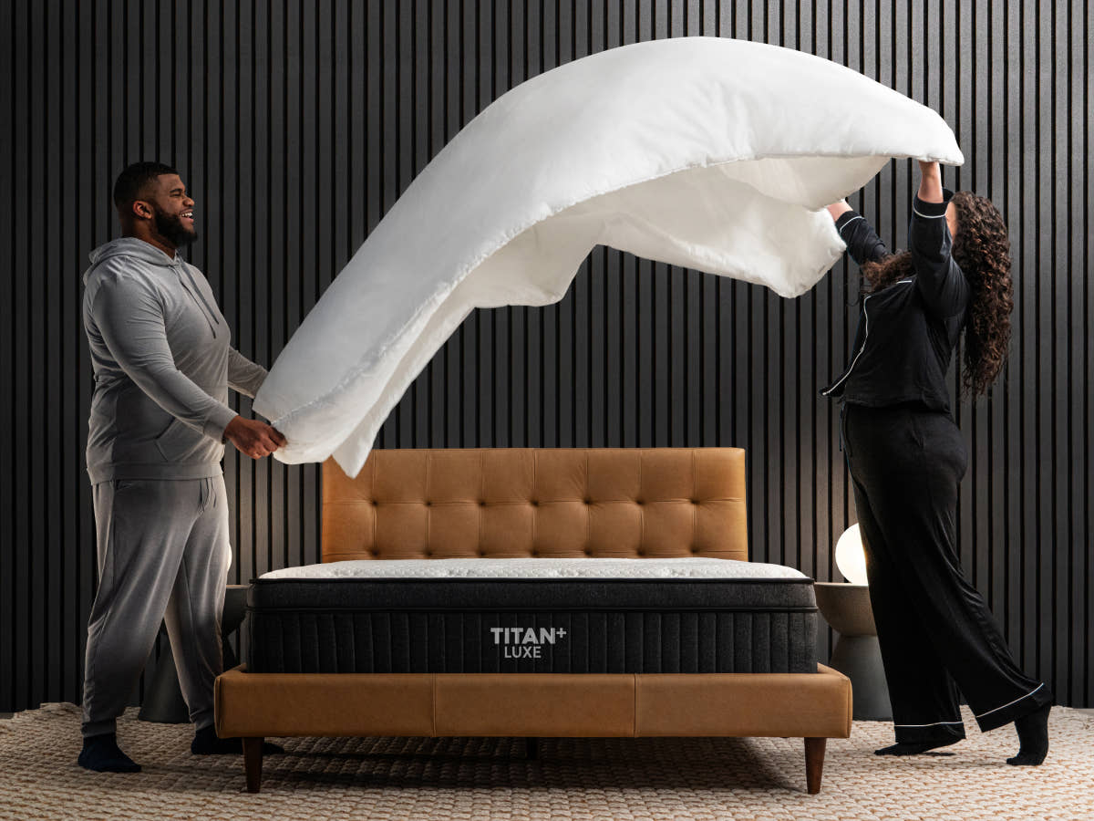 Lifestyle image of two people making the bed of Titan Plus Luxe