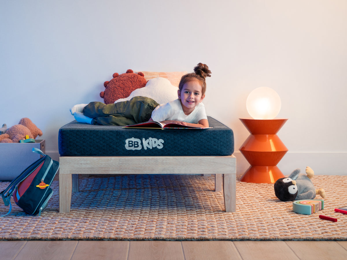 Kid laying reading on  Brooklyn Bedding Kids Mattress