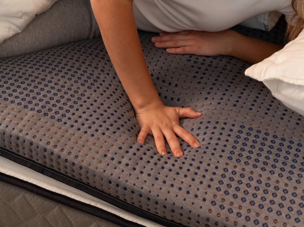 Hand pressing into the CopperFlex 201 Mattress Topper to demonstrate pressure relief and contouring support.