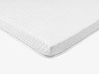 Side view of a white quilted mattress topper 