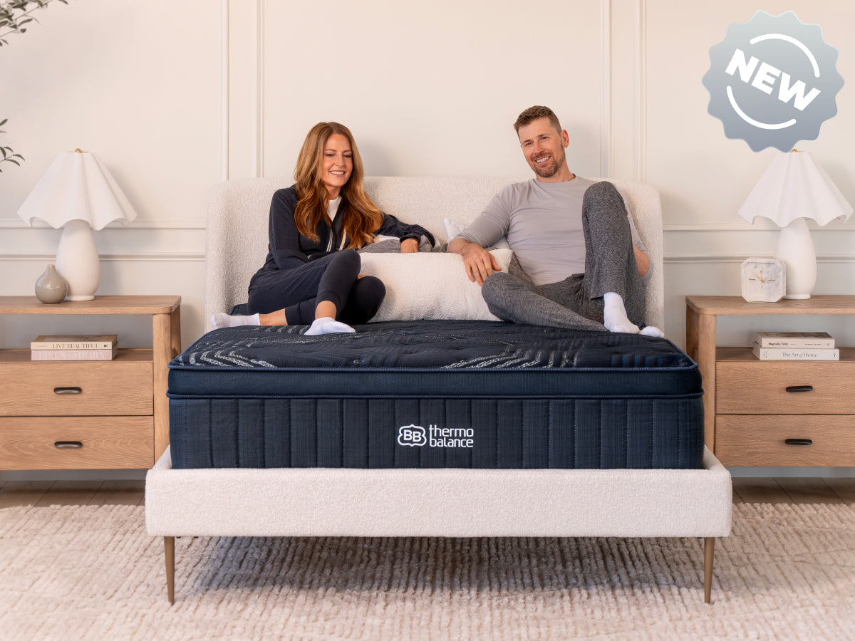 Brooklyn Bedding ThermoBalance Mattress with two people sitting on the bed, with a badge reading “NEW.”