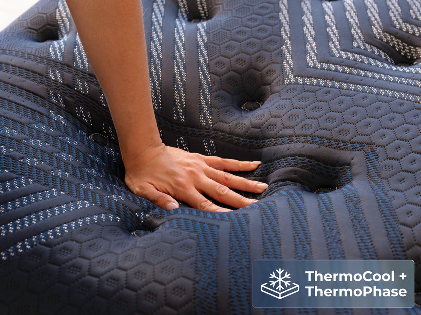 Hand on ThermoBalance mattress showing ThermoCool ThermoPhase cooling features