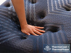 Brooklyn Bedding ThermoBalance Mattress close-up with a hand pressing into the quilted surface, with a badge reading “ThermoCool + ThermoPhase.”