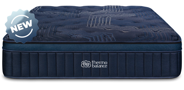 Couple sitting on ThermoBalance Elite mattress in styled bedroom