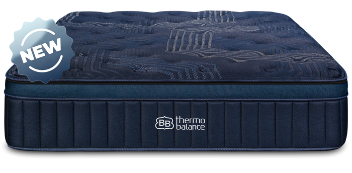 Couple sitting on ThermoBalance Elite mattress in styled bedroom