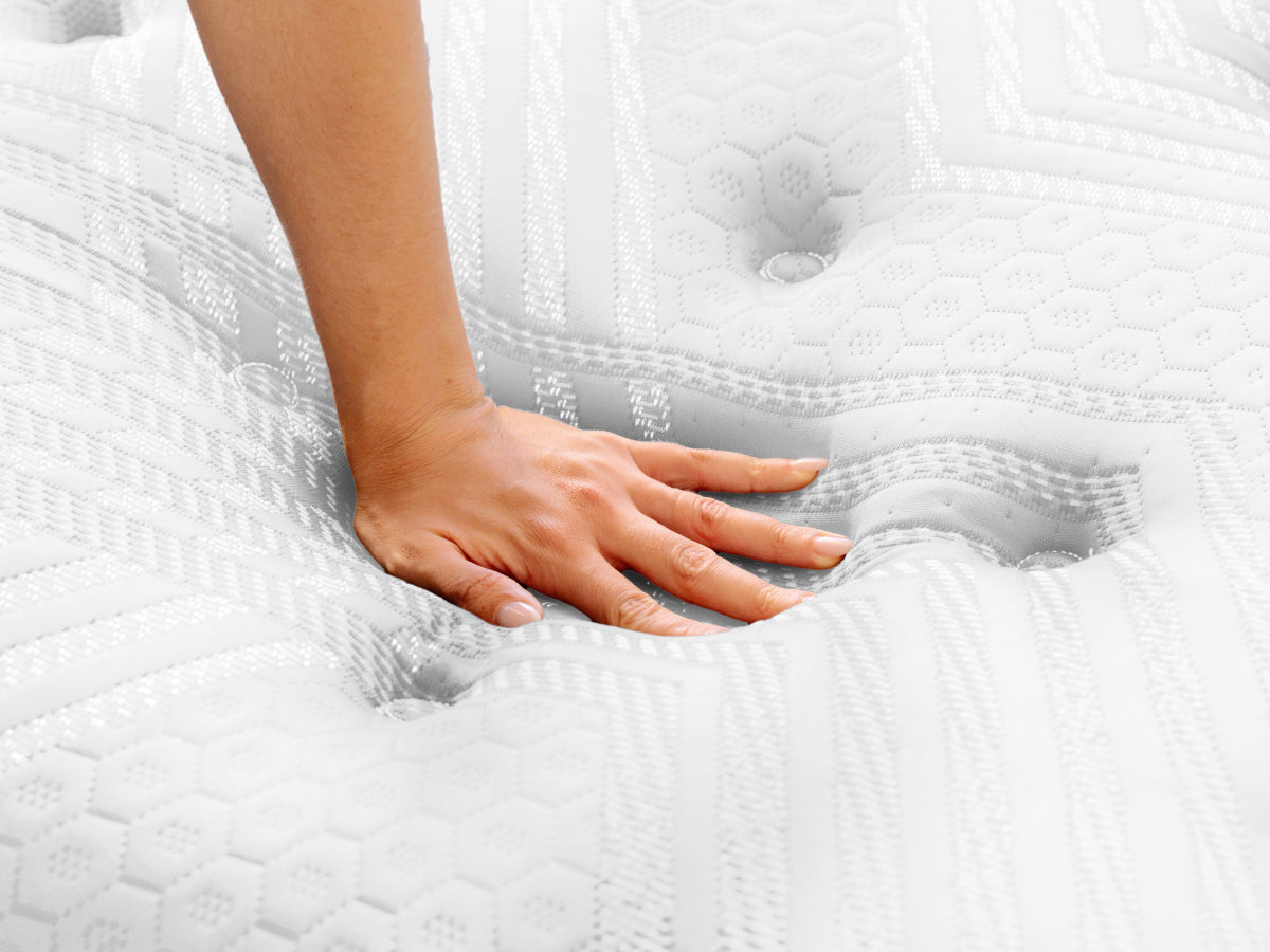 Brooklyn Bedding ThermoBalance LX close-up with a hand pressing into the white quilted surface.