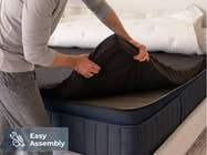 Brooklyn Bedding ThermoBalance LX Elite Mattress with a person placing the cover over the mattress, with a badge reading “Easy Assembly.”