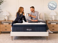 Brooklyn Bedding ThermoBalance LX Elite Mattress with two people sitting on the bed, with a badge reading “NEW.”